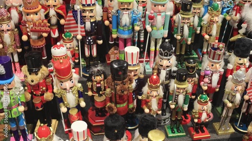 A large collection of colorful nutcracker figurines displayed at a Christmas market, capturing festive holiday decor in a vibrant, detailed scene.