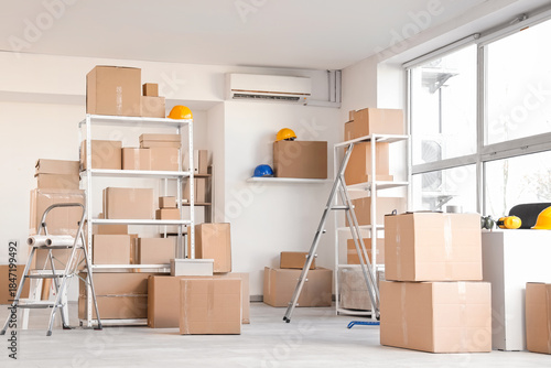 Quadro em tela Interior of warehouse with shelf units, cardboard boxes and stepladders