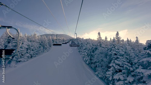 Ski chairlift at Killington Mountain, Vermont. Riding a lift in winter while snow skiing and snowboarding with white snowy trees and mountains. 4K video.