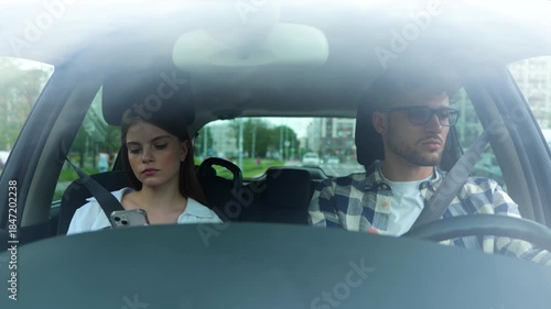 Wallpaper Mural Couple driving in a car and fastening seat belts. Young lady using smartphone. Transport, travel, relationships, safety concept. Slow motion Torontodigital.ca