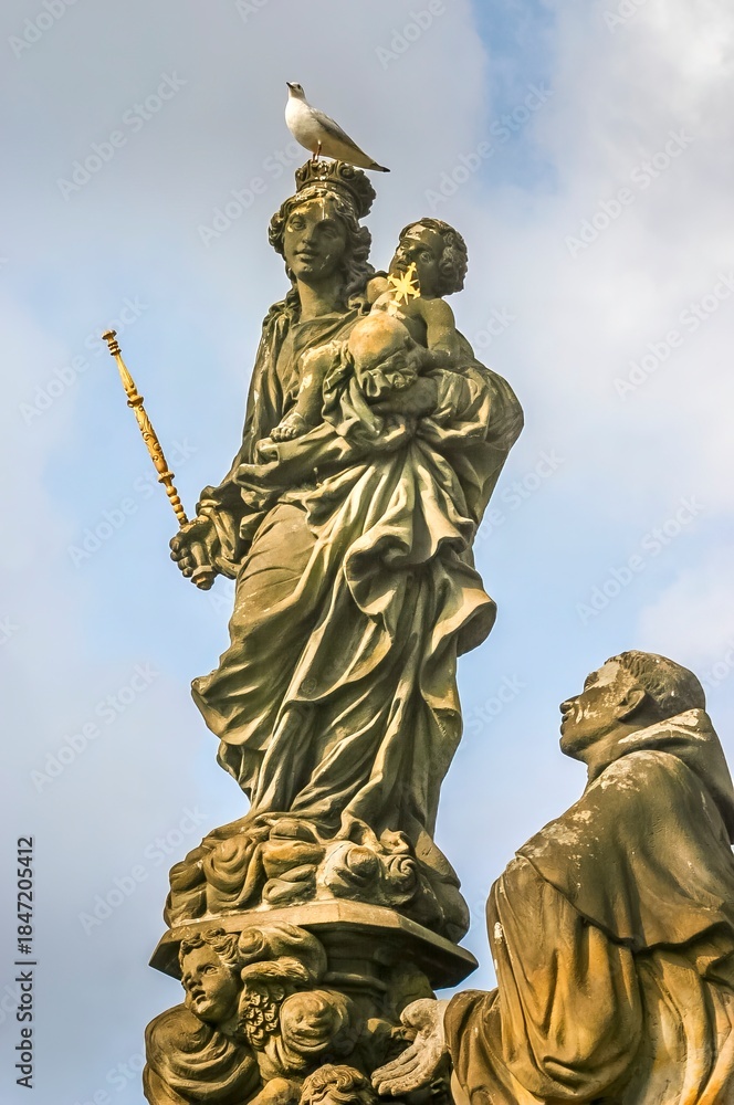Fototapeta premium Statue Of The Madonna, Ss. Dominic And Thomas Aquinas in the Charles Bridge in Prague, Czech Republic