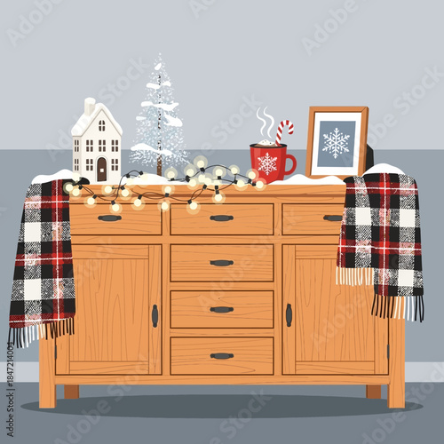 Cozy holiday decorations on wooden sideboard with winter themed decor and festive accessories