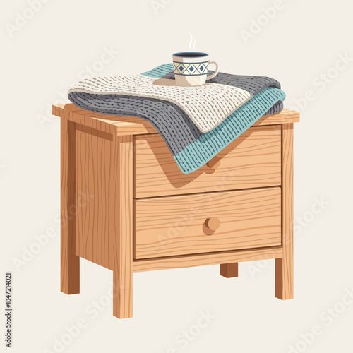 cozy nightstand with folded blankets and cup on top creating a warm bedroom ambiance