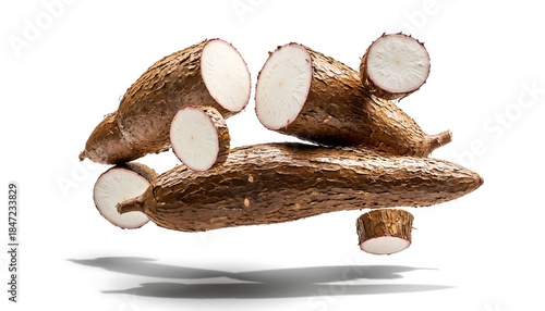 Fresh cassava roots hovering with rough brown skin and visible white flesh texture, soft natural shadow below, isolated on a bright clean white background in realistic studio style.