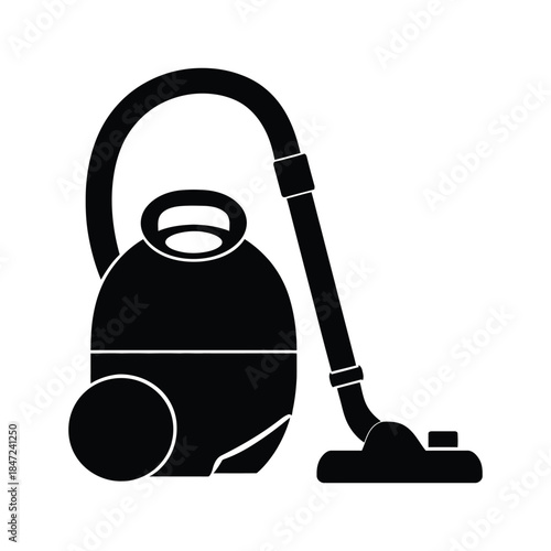 Black canister vacuum cleaner stands ready with hose attached on a white background
