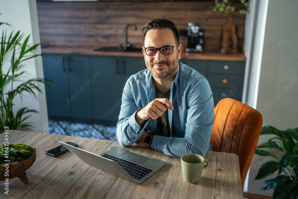 Fototapeta premium Man smiling working from home office freelance lifestyle
