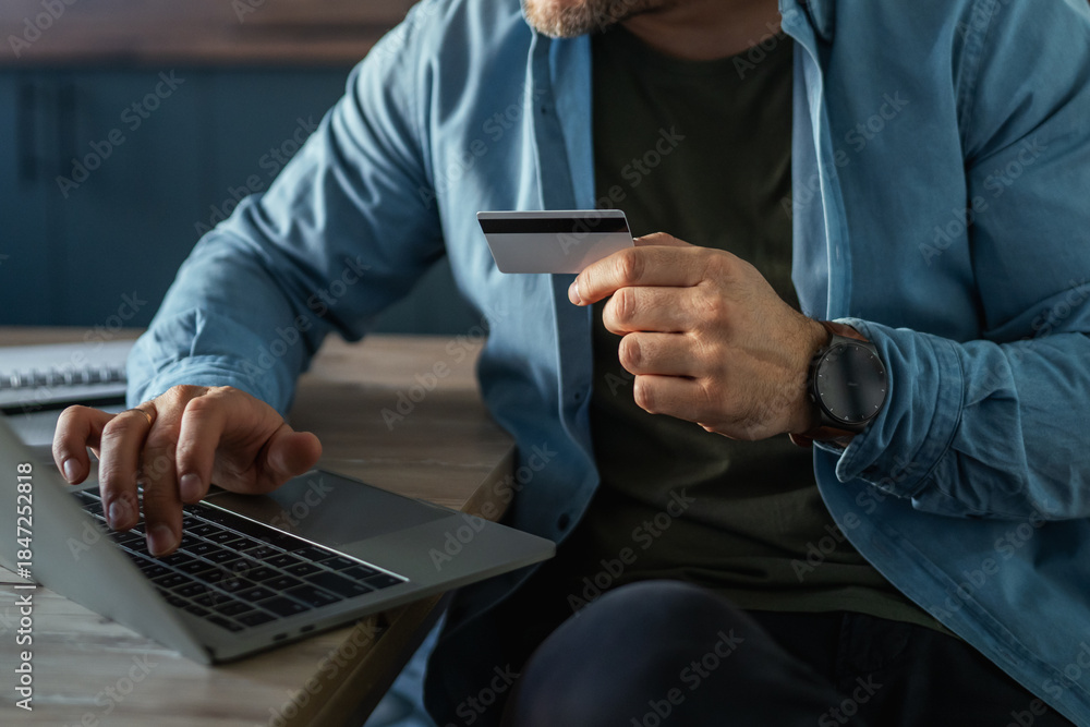 Fototapeta premium Man making secure online payment using credit card and laptop