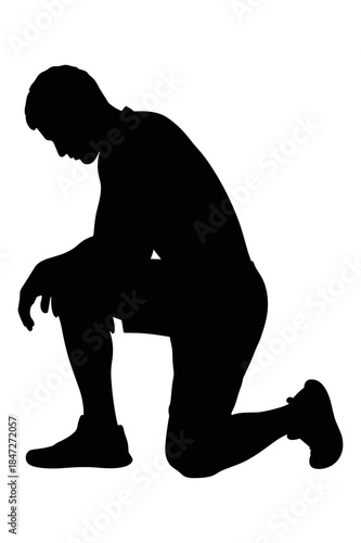 Silhouette of a man kneeling down in a moment of rest or despair after exercise