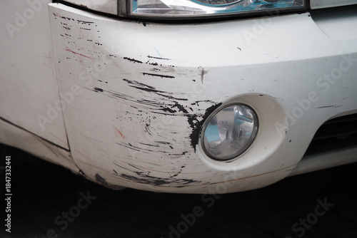 Cuadro en lienzo Car with scratches on the front bumper parked in the street