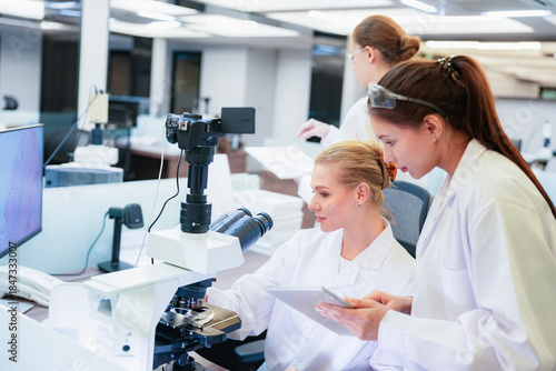 Quadro em tela Diverse team of female scientists working in busy digital pathology lab