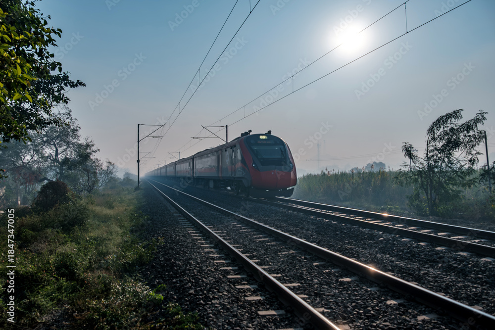 Obraz premium Saffron coloured Vande Bharat Express near Pune India. This is a made in India train set and also known as Train 18.