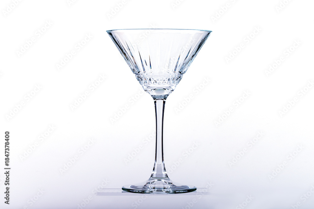 Obraz premium Empty martini glass on glass shelf on white background.