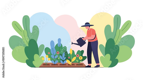 Person in wide hat waters a vibrant raised garden bed of flowers and leafy plants outdoors in garden
