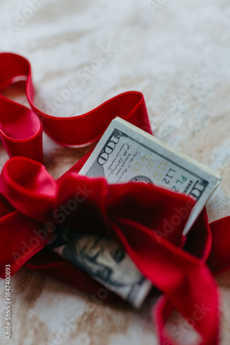 Hundred dollar bills tied with red ribbon
