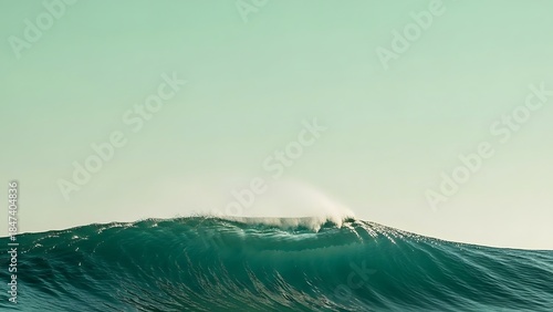Fototapeta Naklejka Na Ścianę i Meble -  A powerful, translucent green wave barrels and curls against a soft, pale green sky, capturing a moment of natural force.