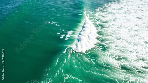 Fototapeta Naklejka Na Ścianę i Meble -  Aerial view of a vibrant green ocean wave with white sea foam