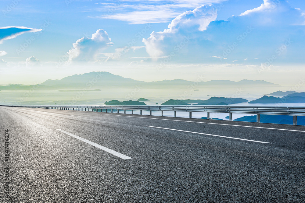 Fototapeta premium Empty asphalt road and blue sea with mountain natural landscape under blue sky