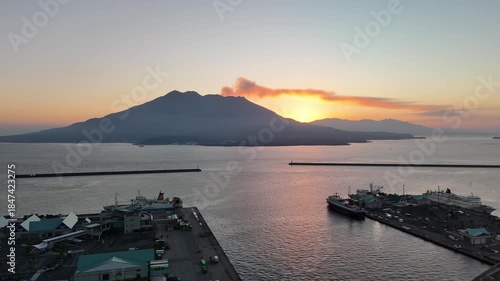 Sakurajima Volcano at Sunrise, Kagoshima, Kyushu Island, Japan – 4K Aerial Drone View of Active Volcano, Golden Morning Light, Calm Bay Waters and Dramatic Mountain Silhouette