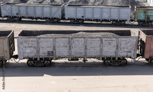 Принти на полотні Weathered coal freight cars sit on rusted tracks in a busy rail yard