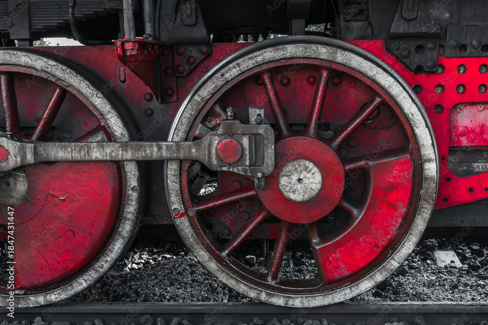 Fototapeta premium A detailed view of a red steam locomotive wheel set, showing weathered metal