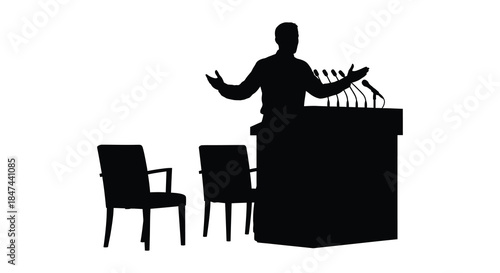 A speaker presenting at a podium with empty chairs in a stark dramatic silhouette
