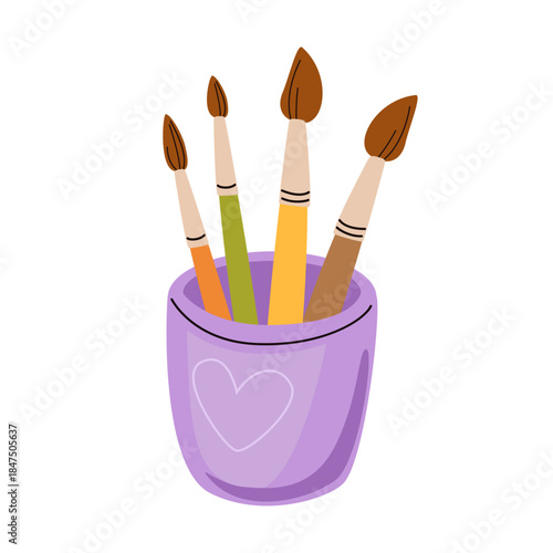 Purple glass with four paint brushes. Glass cup with heart, colorful watercolor accessories