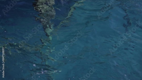 Close-up view of rippling blue ocean water with sunlight reflections. Slow motion.