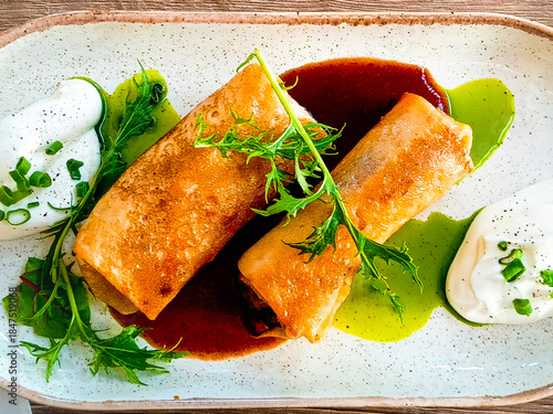 Fried pancakes with filling and sauce served in a restaurant. Close-up, selective focus.