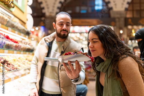 Photography Tourist smelling dried fruits in Istanbul spice market bazaar