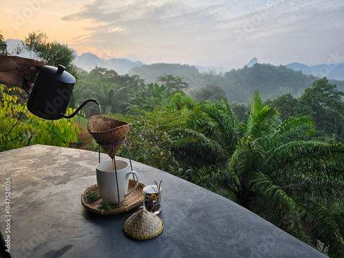 Morning coffee ritual overlooking Khao Soks lush landscape in Thailand