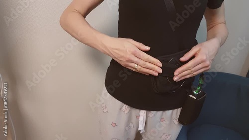 Woman patient demonstrating wearable recording device of capsule endoscopy procedure. Healthcare