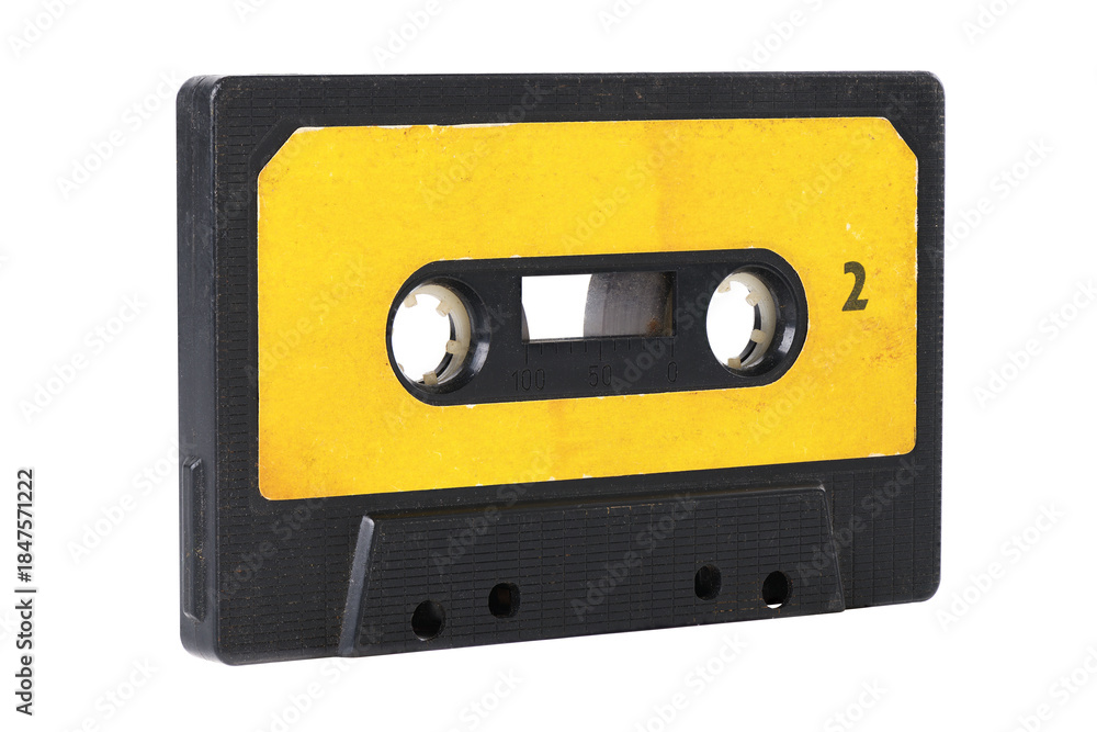 Fototapeta premium Old yellow cassette tape with music tracks from the past isolated on white background.