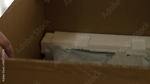 Worker Opening Cardboard Box with Kitchen Appliance