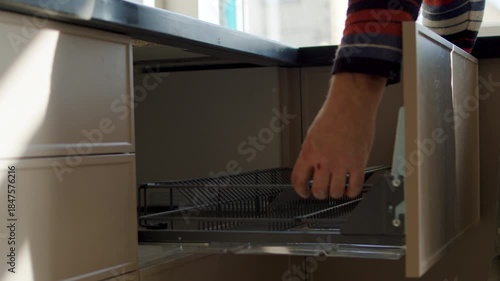 Worker Installing Metal Shelf Inside Kitchen Drawer