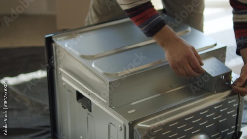 Worker Preparing Built-in Kitchen Oven for Installation