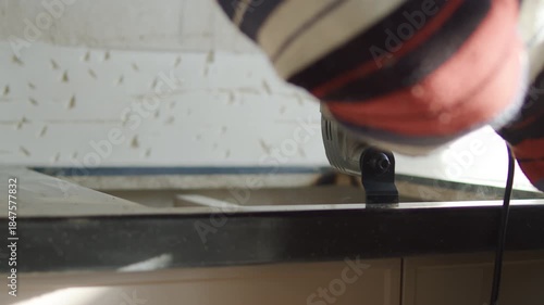 Worker Cutting Kitchen Countertop with Electric Grinder