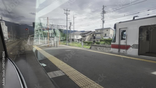 The train pulls into a station and slows to a stop, with clouds drifting slowly and traffic lights flashing rhythmically.