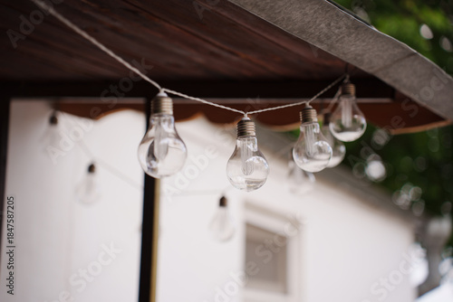 String lights hang over a wooden structure in daylight