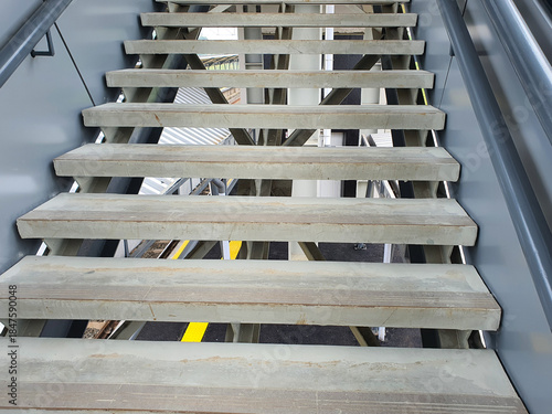 Upward perspective view of a modern industrial staircase with wooden steps.