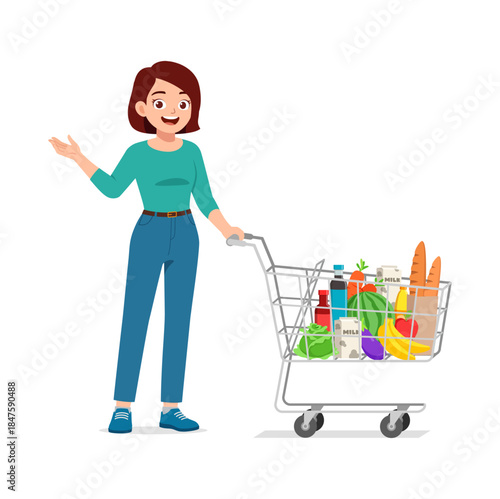 Happy smiling woman pushing a full grocery cart filled with fresh food and healthy products