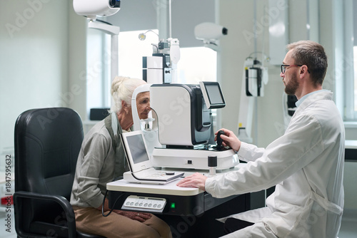 Fotografia Senior Caucasian woman undergoing eye examination with ophthalmologist using adv