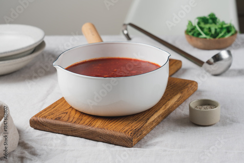Traditional beetroot borscht soup in ladle on linen tablecloth, rustic homemade dish