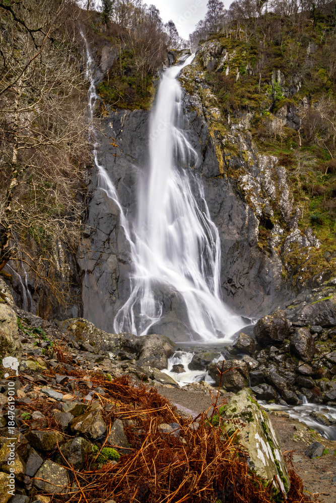 Obraz premium Long exposure image of a waterfall and mountain river; Aber Falls, Rhaeadr Fawr,Snowdonia Wales