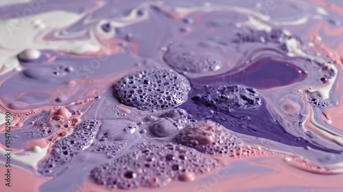 Paint pour featuring white, lilac and light pink colors intermingling in swirling, organic patterns
