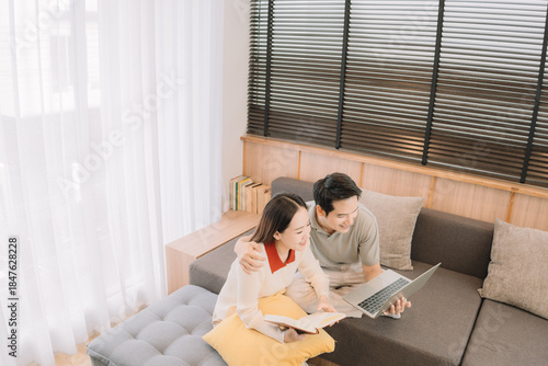 Happy Asian couple enjoying time together in their new home