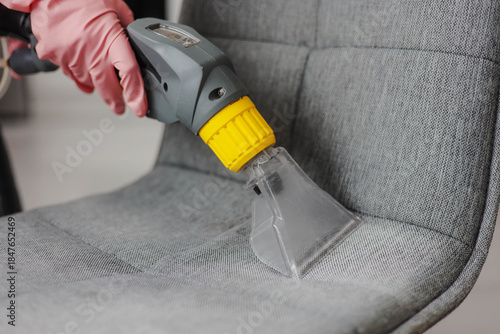 Cuadro en lienzo Close up of professional cleaner providing deep cleaning of a fabric chair using vacuum cleaner