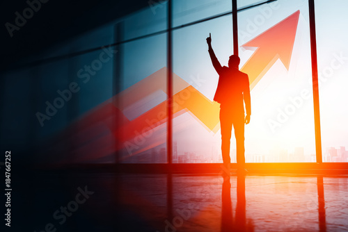 Silhouette of a businessman pointing upward against a backdrop of a rising arrow, symbolizing success and growth in business.