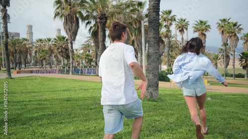 A delightful moment captured of two friends engaging in a playful chase, showcasing the joy of companionship and carefree laughter in a beautiful park setting filled with greenery.