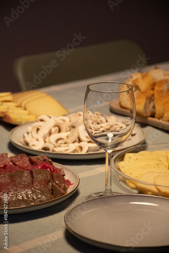 cold table blurred in the background for foundue breakfast empty wine glass raw meat romantic
