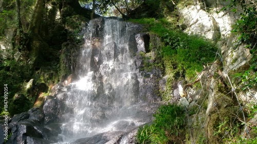 Takachiho Gorge in Takachiho, Miyazaki, Kyushu, Japan, Waterfall flowing over rocks in lush green forest nature landscape